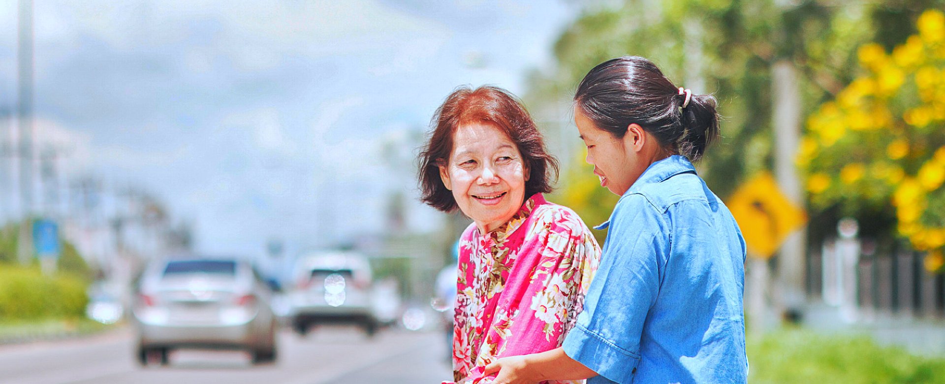 caregiver assisting elder woman in walking